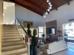 a living room with a staircase and a couch at Porto Center Hotel in Luís Eduardo Magalhães