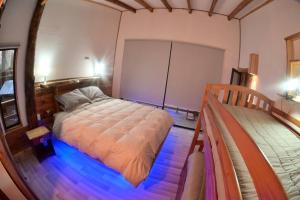 Un dormitorio con una cama con luces azules. en Sendero del Zorro, Km 41,5 ruta N-55 en Chillán