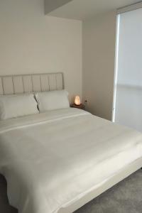 a large white bed in a room with a lamp at GGP Boutique Townhome in Vaughan