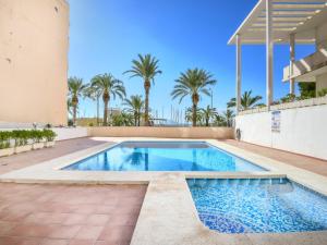 a swimming pool in the backyard of a house with palm trees at Apartment Marina in Calpe