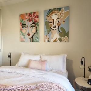 ein Schlafzimmer mit drei Gemälden an der Wand über einem Bett in der Unterkunft Piper Apartment in Bathurst