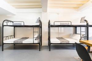 two bunk beds in a room with a table at Diamond Hall Cebu - 103 in Cebu City