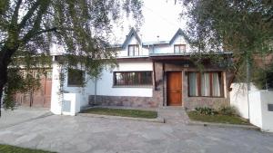 una casa blanca con una entrada delante de ella en La Querencia Esquel, en Esquel