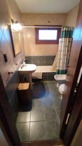 Un baño con lavabo, inodoro y bañera. en La Querencia Esquel, en Esquel 20 fotos más