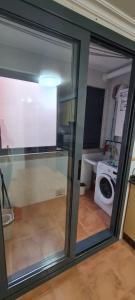 a sliding glass door in a room with a washing machine at Tu dulce hogar, apartamento completo,céntrico con wifi y parking gratuito in Vigo