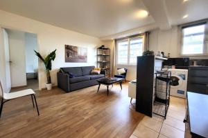 sala de estar con sofá y mesa en L'Essentiel - Appartement lumineux proche de tout, en Arcueil