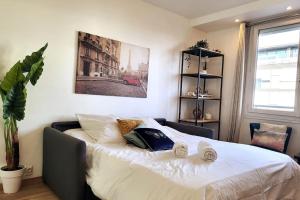 1 dormitorio con 1 cama grande y 2 almohadas en L'Essentiel - Appartement lumineux proche de tout, en Arcueil