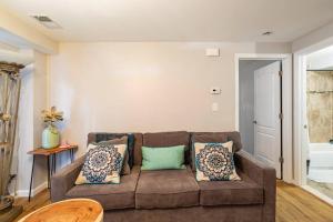 uma sala de estar com um sofá castanho com almofadas em Free Access to Manhattan with Free Parking em Tompkinsville