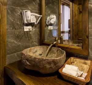 a bathroom with a stone sink and a mirror at Maison de Lao Chai in Sapa