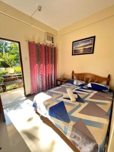 1 dormitorio con 1 cama con un edredón colorido en DIAKOPES INN en Puerto Princesa