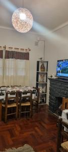 sala de estar con mesa, sillas y chimenea en Hostel Black Lions en Mendoza
