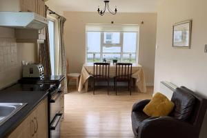 a kitchen and dining room with a table and chairs at Elegant Lahinch/ Liscannor Cottage 3B 3BR in Liscannor