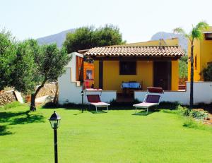 a house with two chairs and a lamp in the yard at Vento di Grecale in Favignana