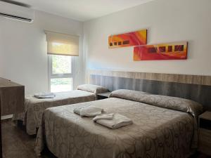 a room with two beds with towels on them at Apartamentos Bella Vista in Bella Vista