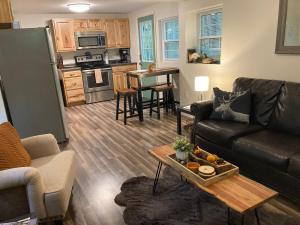 a living room with a couch and a table at Cute private Wooded Cabin near the big lake in Tafton