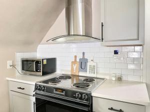 a kitchen with a stove and a microwave at Serenity Studio, Adorable and Spacious Studio with Full Kitchen in High Point