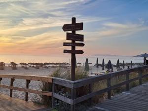 una señal direccional en una playa con sombrillas en Casa Atlântico Carvalhal Comporta, apartamento piscina aquecida, en Carvalhal