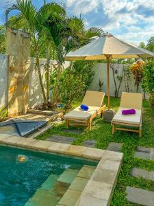 two chairs and an umbrella next to a swimming pool at Nate's Villa - 2 Bedroom Villa Private Pool near Lovina Bali in Banjar