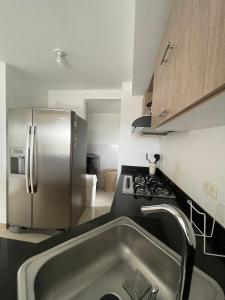 a kitchen with a stainless steel refrigerator and a sink at Apartamento sur de cali in Cali