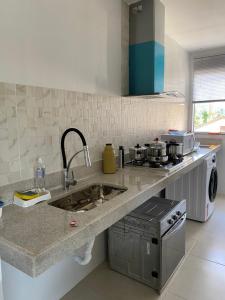 a kitchen with a sink and a stove at Apartamento completo no centro de Domingos Martins in Domingos Martins