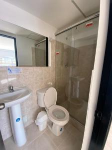 y baño con aseo, lavabo y ducha. en HOTEL HOME UNICENTRO, en Villavicencio