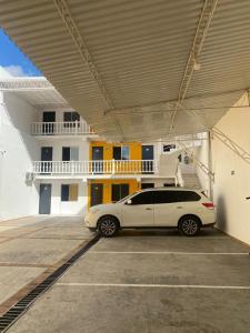 un coche aparcado en un aparcamiento frente a un edificio en HOTEL HOME UNICENTRO, en Villavicencio