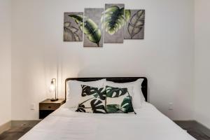 Un dormitorio con una cama con cuadros de hojas verdes en la pared. en Stylish 2 Bedroom Apartment in Medical District, en Dallas