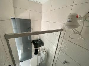 a bathroom with a shower with a toilet and a light at Ytamãní ll apartamentos in Santa Cruz Cabrália