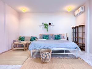 a bedroom with a bed with blue pillows at At The Beach Apartments in Panwa Beach