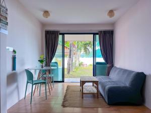 a living room with a blue couch and a table at At The Beach Apartments in Panwa Beach