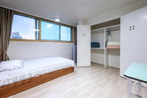 um quarto com uma cama e uma janela em A Four Leaf Clover House em Namyangju