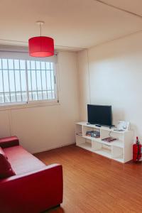 a living room with a red couch and a tv at KooColand- XUMUC in Tupungato