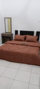 a bed with a red comforter and a mirror at QM_Homestay Bagan Serai in Bagan Serai