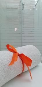 un rollo de toallas con una cinta naranja. en Il sole, en Maruggio