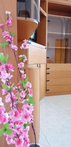 una rama de flores rosas en una habitación en Il sole, en Maruggio