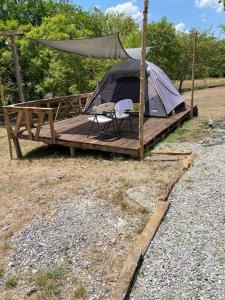 a tent with two chairs on a wooden deck at GLAMPING KAAN JA in Tanchachín