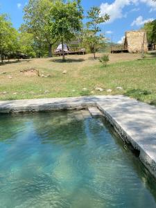 a large pool of water with a field in the background at GLAMPING KAAN JA in Tanchachín