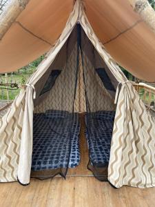 a tent with two beds in it on a wooden floor at GLAMPING KAAN JA in Tanchachín