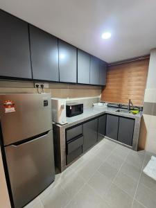 Una cocina con electrodomésticos de acero inoxidable y gabinetes de madera. en Ndw appartment. Clean house + NEW furniture, en Kuala Terengganu