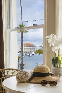 a hat and sunglasses sitting on a table in front of a window at Hotel Mac Rae in Avalon