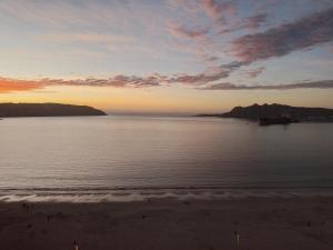 una vista del océano al atardecer con una playa en Condominio Bahia Horizonte, en Coquimbo