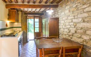 a kitchen with a table and a stone wall at Cozy Home In Castiglion Fiorentino in Castiglion Fiorentino