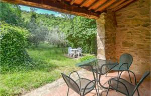 a patio with a table and chairs in a yard at Cozy Home In Castiglion Fiorentino in Castiglion Fiorentino