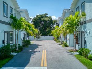 a street between two buildings with palm trees at 30 Guests 3 Identical Brand New Townhomes in Downtown Fort Lauderdale in Fort Lauderdale