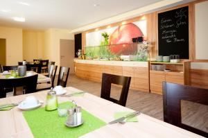 a restaurant with tables and chairs and a chalk board at Hotel Bauer in Rauchenwarth