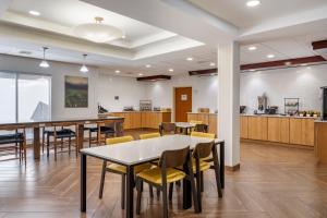 a dining room with tables and chairs and a kitchen at Fairfield Inn & Suites Cherokee in Cherokee