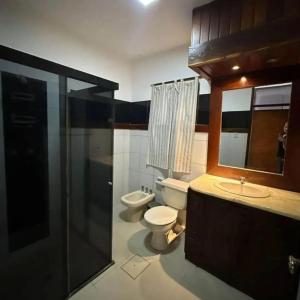 a bathroom with a toilet and a sink and a mirror at Guajira Hostel SCZ in Santa Cruz de la Sierra