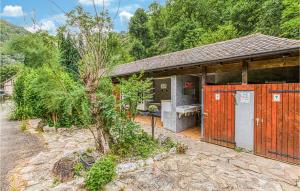 una casa con un edificio con puertas rojas en Stunning stacaravan In Conques En Rouergues With Outdoor Swimming Pool, en Conques-en-Rouergue