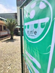 a sign on a fence in front of a building at Turtle GuestHouse- White beach in Puerto Galera