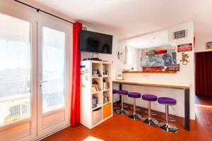 a kitchen with a bar with purple stools at Magnificent apartment typical of Saintes-Maries-de-laMer in Saintes-Maries-de-la-Mer